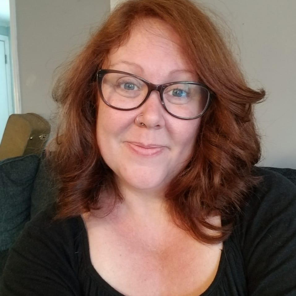 Picture of a woman with red hair and glasses.