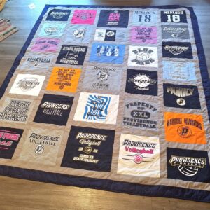 Handmade quilt made from t-shirts., lying on hardwood floor