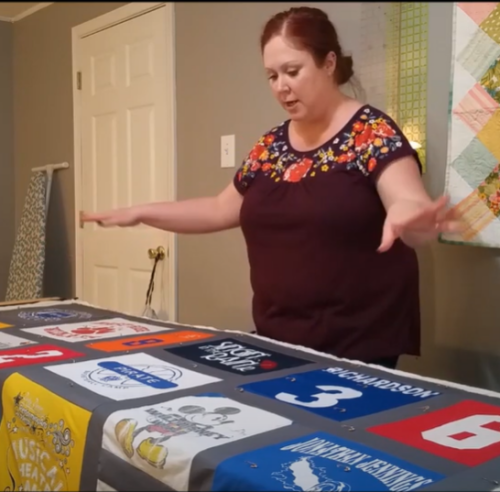 Summer Lee standing over a t-shirt quilt
